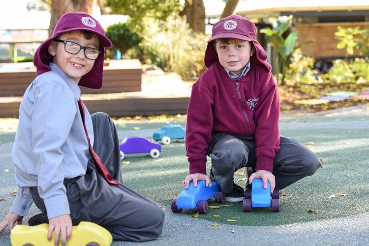 Two students playing on the car track
