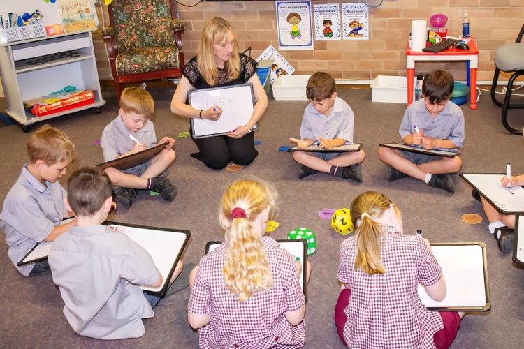 Small gorup maths instruction. Teacher instructing a small group of students.