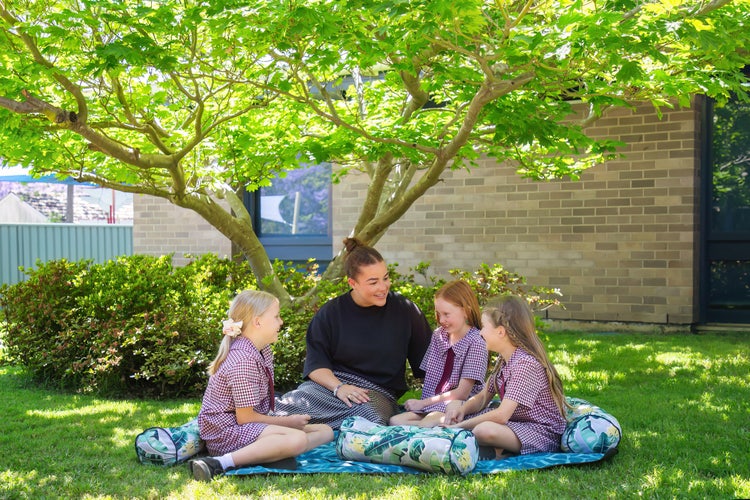 SLSO staff member talking to three girls.