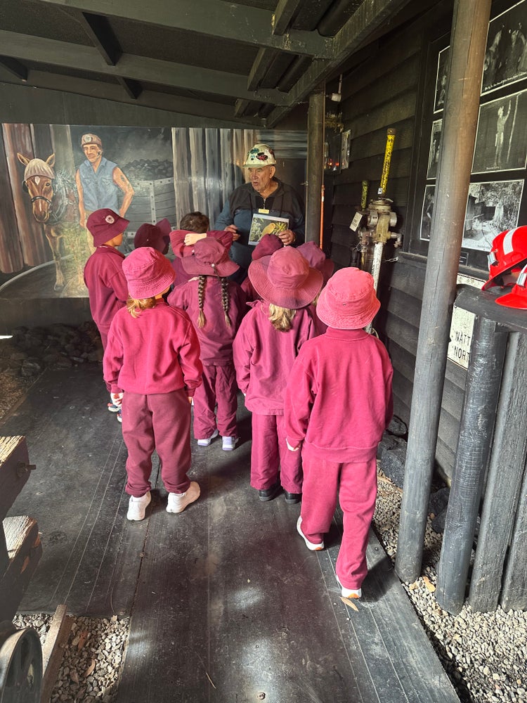 Stage 1 students listening to a presentor at an excursion.